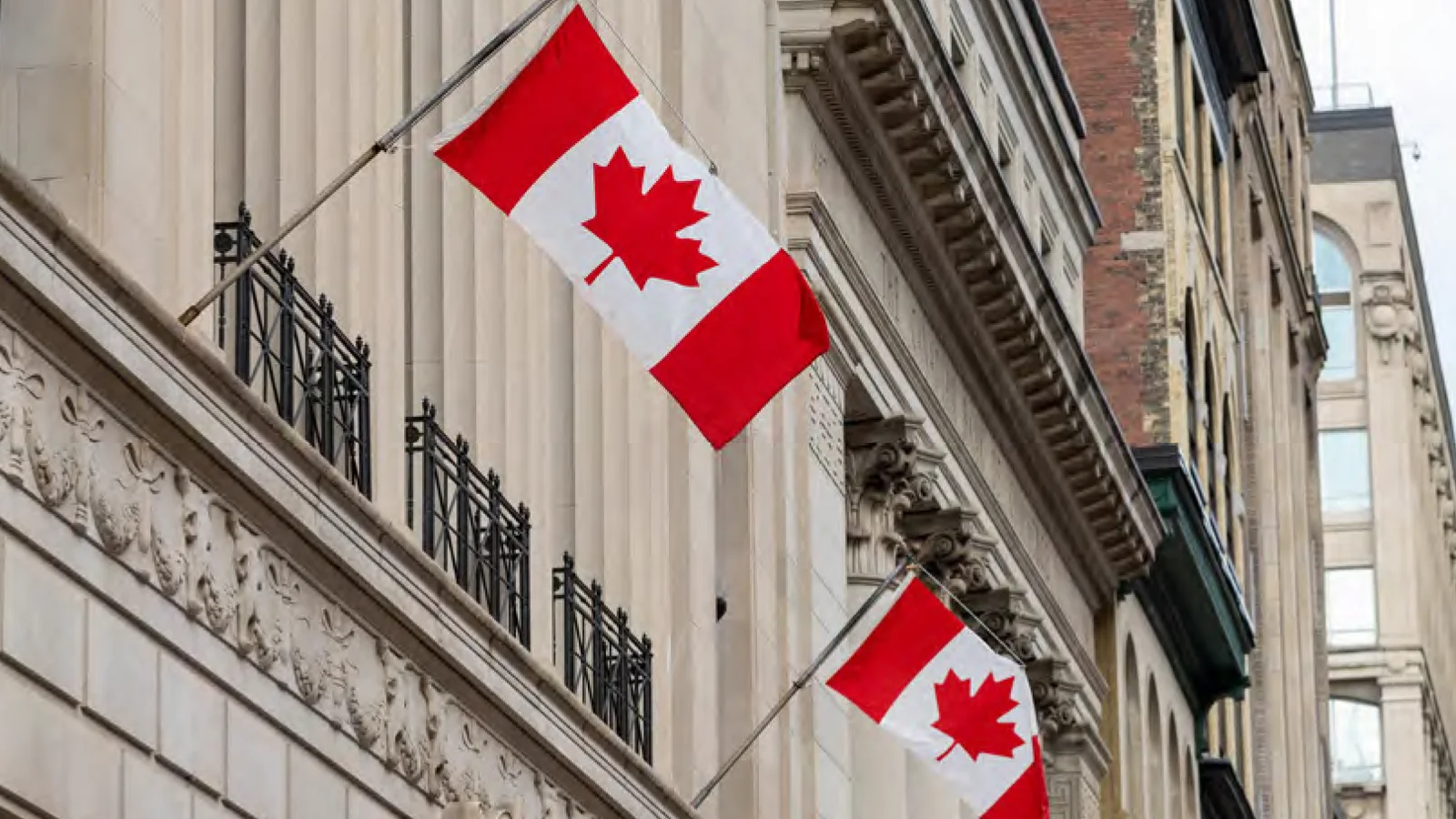 加拿大国旗悬挂在政府大楼外，象征《2025年度预算案》中基础设施投资计划。